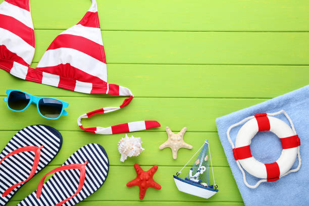 istock Summer accessories with decorative ship and seashells on green wooden table 1048843308