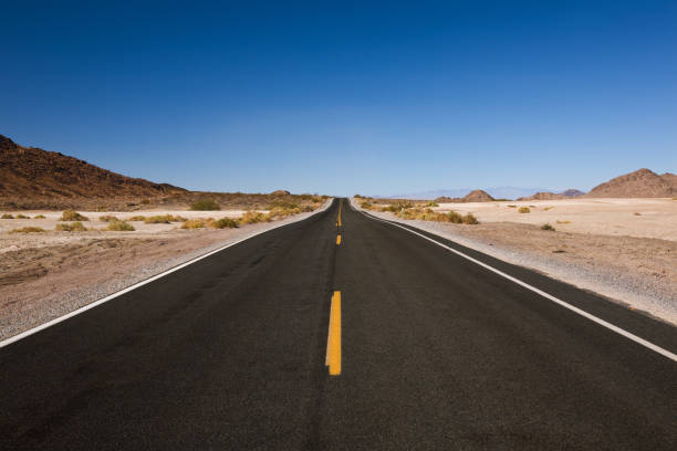 Straight, empty, two-lane road in the middle of the desert stock photo
