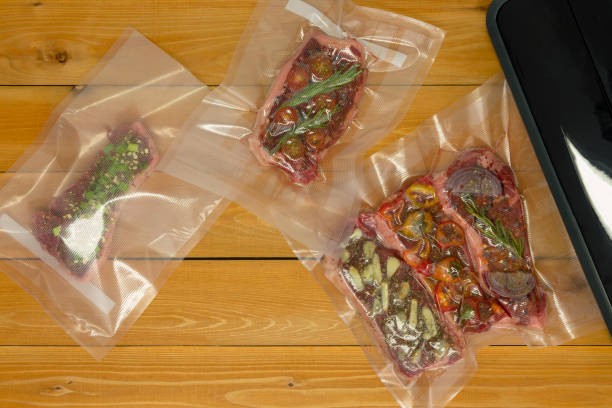 istock Plastic bags filled with meat next to vacuum sealer 1048851776
