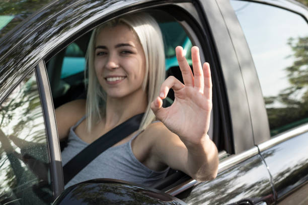 istock happy young girl driving the car 1048853542