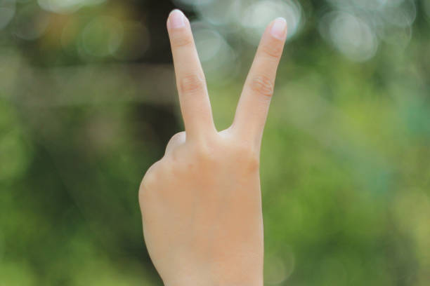 istock two finger women, blur bokeh nature background 1048863862