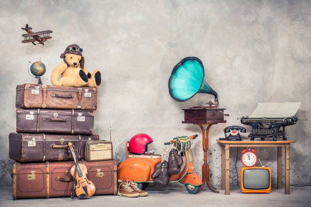 retro teddy bear toy in aviator's hat, wooden plane, aged classic travel valises, globe, children pedal scooter, phonograph, typewriter, clock, tv, radio, old telephone. vintage style filtered photo - radio gramophone imagens e fotografias de stock