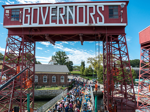 Tourists visiting  Governors Island, New York City. It is a popular tourist attraction in New York Harbor and is accessible by ferry from Lower Manhattan.
The welcome sign to Governors Island on the Manhattan side from the ferry at the dock early in the day as passengers disembark the ferry.