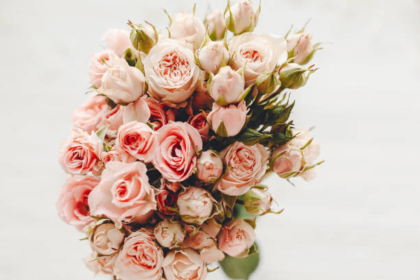 istock Pink small roses bouquet on white background isolated.  Top view with space for text. Floral greeting card mockup. Wedding invitation,happy mother day or Valentine day concept. 1048872608