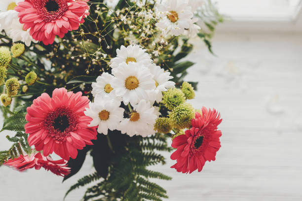 istock Pink gerbera,white daisy and green chrysanthemum in beautiful bouquet at rustic window in light. Wedding invitation,happy mother day or Valentine day concept. Hello spring 1048872842