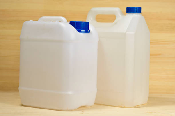 weiße kunststoff-behälter (gallone) auf dem hintergrund der holzwand - red jug stock-fotos und bilder