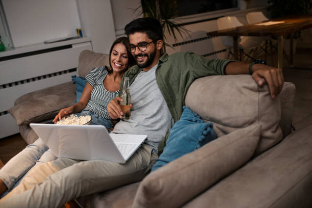 istock Young couple watching a movie on a laptop. 1048876610