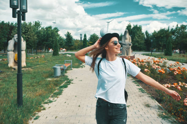 donna sorridente viaggiatrice con uno zaino sulla schiena che cammina - on top of activity adult adventure foto e immagini stock