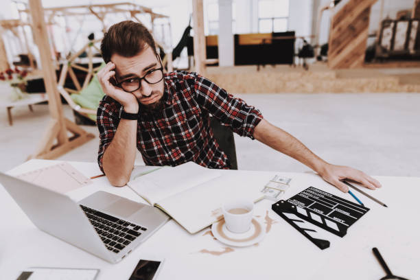 istock Tired Man. Sit at Table. Papers. Laptop. Coffee. 1048882684