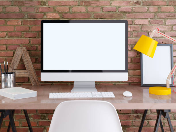 istock mockup monitor on a table with posters on a brick wall. 1048887098