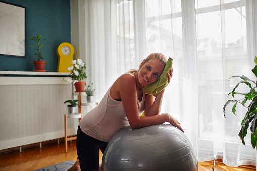 Blonde pregnant woman exercising at home.