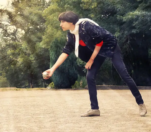 Photo of Woman throwing a petanque ball in th park on holidays