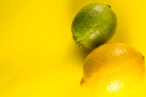 istock Fresh lemon and lime on yellow pastel background. Close up. 1048902038