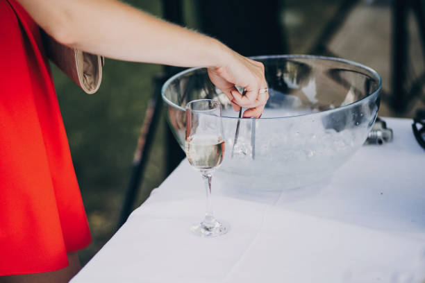 istock woman getting ice for stylish champagne drink on wedding table. luxury drinks for celebration, reception outdoors. catering. christmas feast 1048907642
