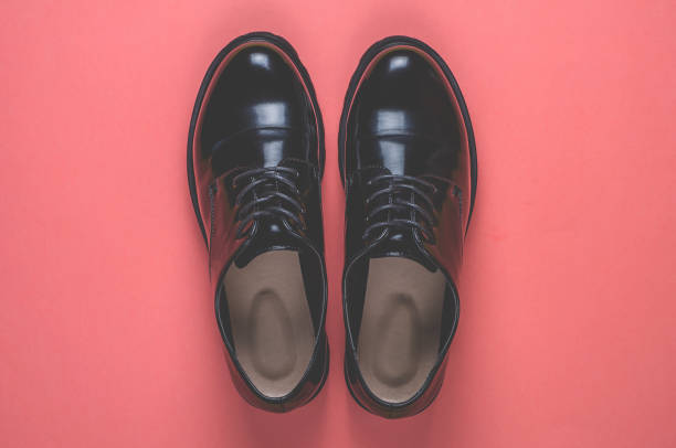 istock Black shoes on pink background 1048911228