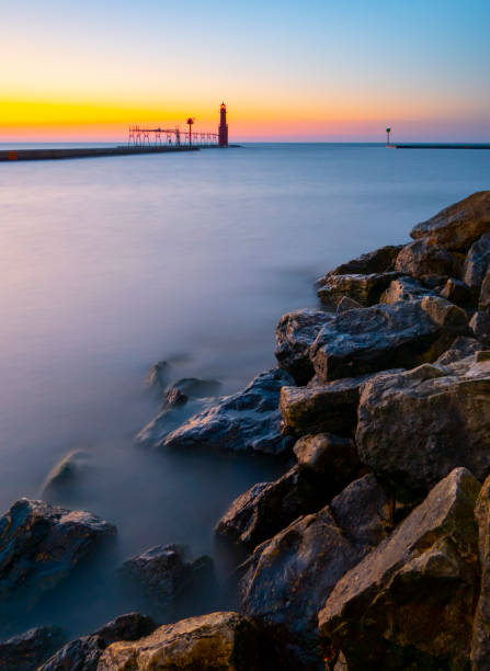 istock Long exposure of rocky shore, harbor with lighthouse. 1048912464