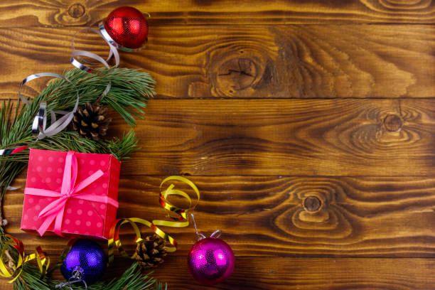 istock Christmas composition with fir tree branches, gift box and Christmas decorations on wooden table. Top view, copy space 1048926302