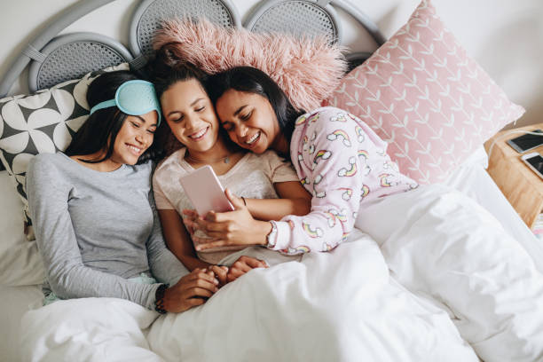 istock Girls enjoying with mobile phone during a sleepover 1048928294