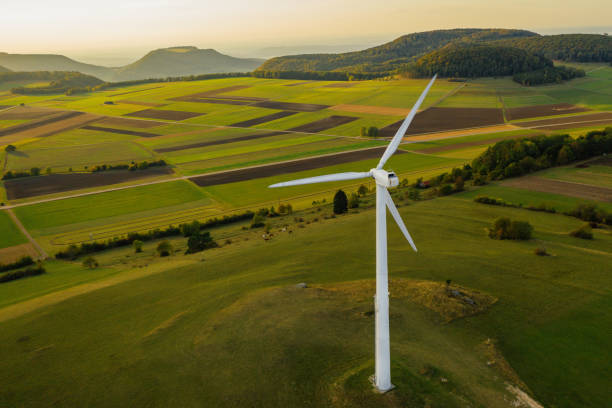 turbina de vento energia alternativa na bela paisagem verde ao pôr do sol - rolling hill field green - fotografias e filmes do acervo