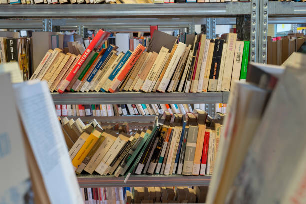 istock books on the shelf in a public library, bound, to be used as a background 1048932572