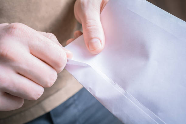 Male Hands Opening The Edge Of An Envelope - Waiting For A Message Concept Male Hands Opening The Edge Of An Envelope - Waiting For Message Concept college acceptance letter stock pictures, royalty-free photos & images