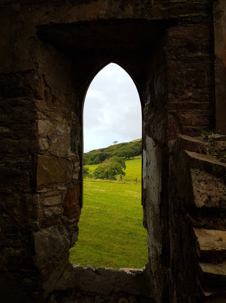 istock Old castle arch window ruins looking out at the Irish countryside 1048937672