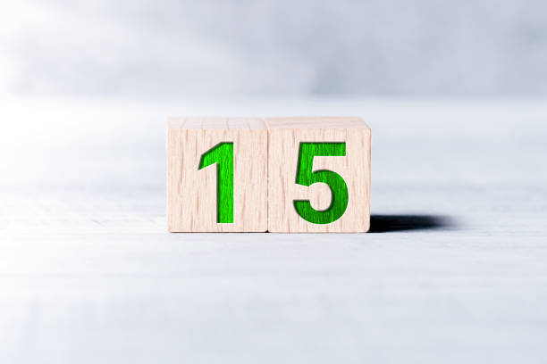 Number 15 Formed By Wooden Blocks On A White Table stock photo