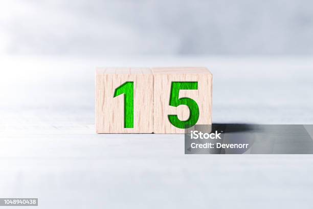 Number 15 Formed By Wooden Blocks On A White Table Stock Photo - Download Image Now - Number 15, Day, Time