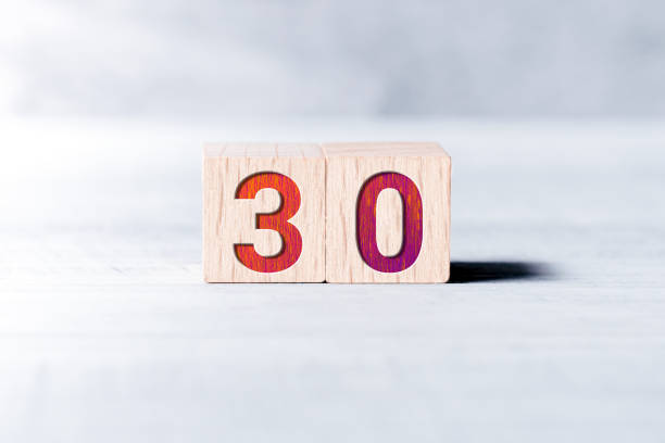 Number 30 Formed By Wooden Blocks On A White Table stock photo