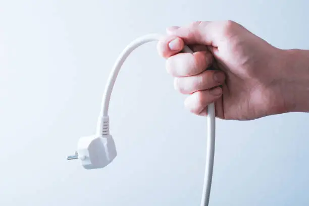 Photo of Male Hand Holding A Power Cable - Saving Energy Concept