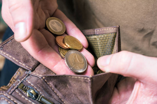 Man Putting Some Euro Coins In His Wallet stock photo