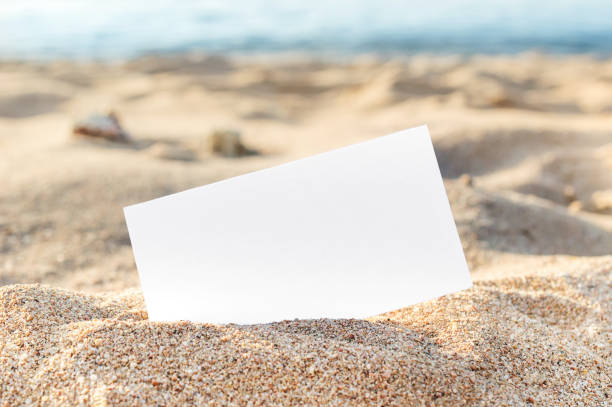 Blank card on sand at sea beach. stock photo