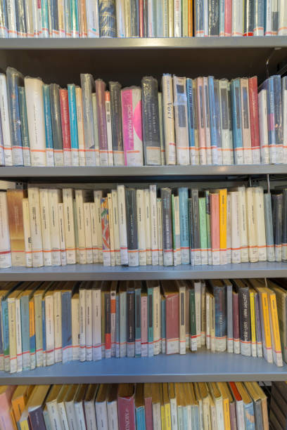 istock books on the shelf in a public library, bound, to be used as a background 1048946416