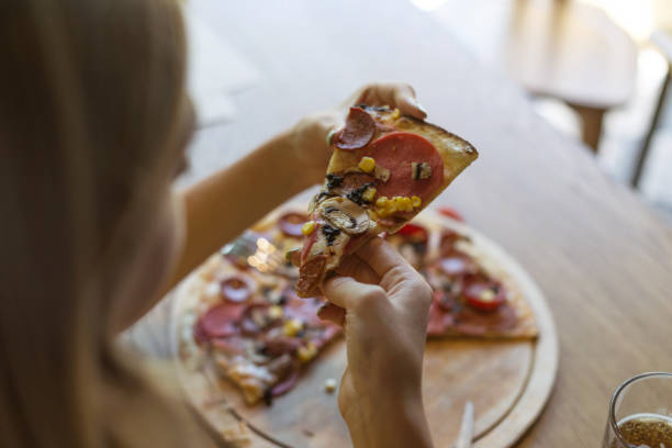 istock Woman holding pizza slice 1048954448
