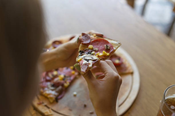 istock Woman holding pizza slice 1048954596