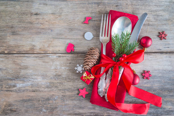 istock Festive table setting for christmas or new year dinner: vintage fork, spoon,knife on red napkin and christmas decorations 1048955826