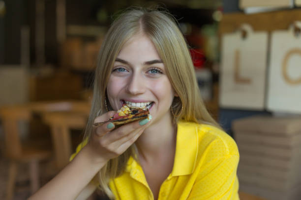 istock Woman biting a slice of pizza 1048958392