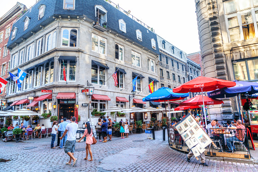 People meander at the junction of Rue Saint-Paul and Rue Saint-Vincent in the Old Montreal section of Montreal. They are the oldest streets in Montreal, Quebec, Canada, famous for the restaurants and unique shops.