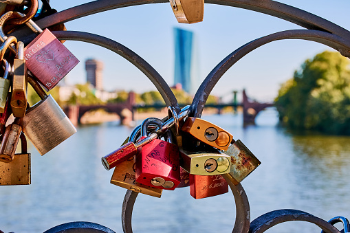 Frankfurt, Germany - September 30, 2018: Eiserner Steg bridge in Frankfurt city with love locks. Behind the love locks is blurred the river Main and the ECB building.