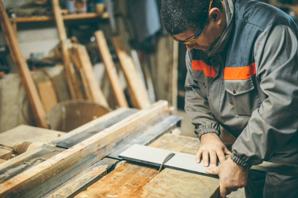 istock Mature man cutting wood with electric saw 1049007662