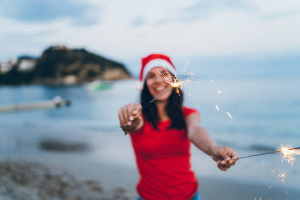 istock Woman holding sparklers on the beach 1049016082