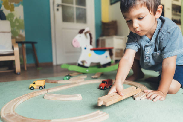 istock Little boy play wiht wooden railway 1049019334