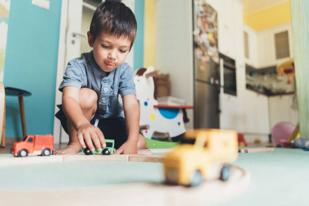 istock Cute little boy playing with wooden train 1049019336