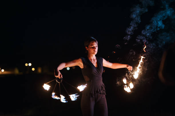 istock Beautiful young woman dancing with fire at night 1049025658