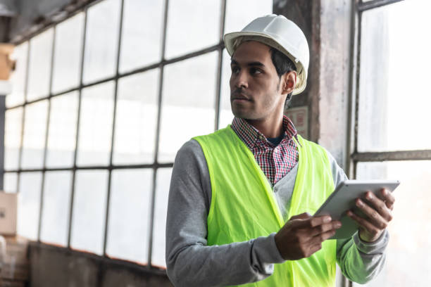 istock Manager of a warehouse holding a tablet while looking away very thoughtful 1049029476