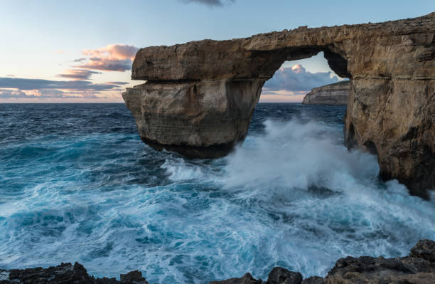 dwejra azur ventana gozo malta. mar chapoteando contra las rocas al atardecer - gozo malta natural arch natural phenomenon fotografías e imágenes de stock