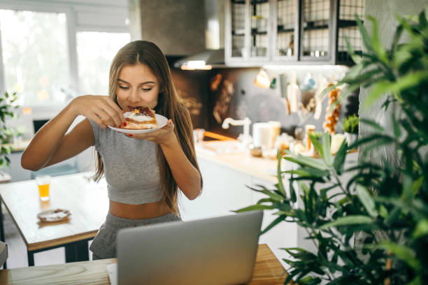 istock Young woman having lunch at home 1049037050
