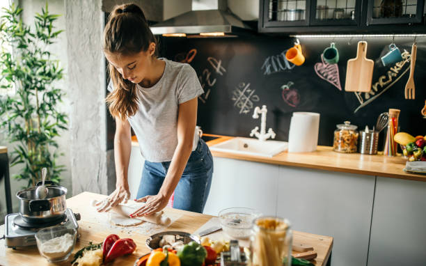 istock Young woman making pizza at home 1049039634