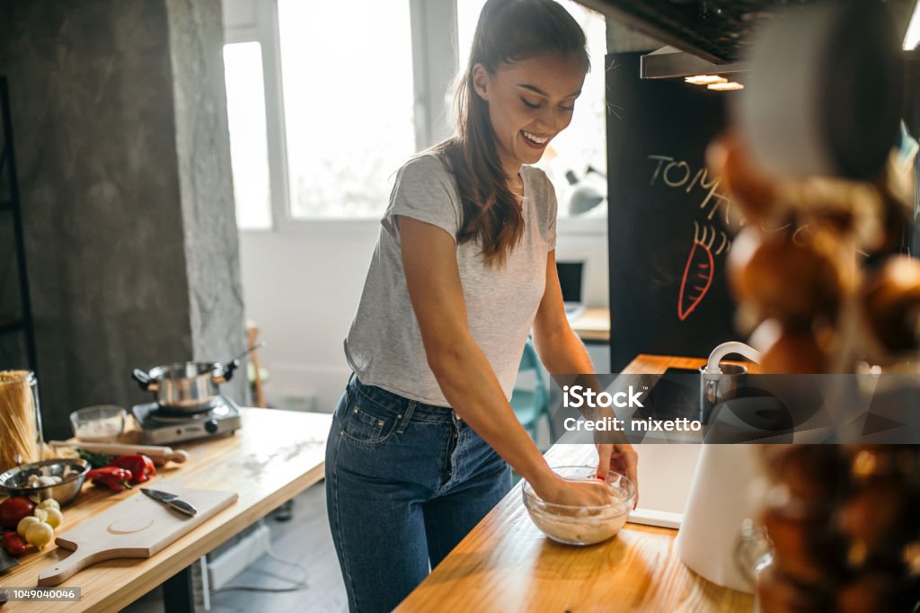 Young woman making pizza in the kichen Photo of young woman making pizza in the kitchen Cooking Stock Photo