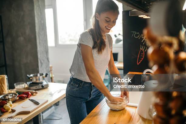 Young Woman Making Pizza In The Kichen Stock Photo - Download Image Now - Cooking, Enjoyment, Kitchen